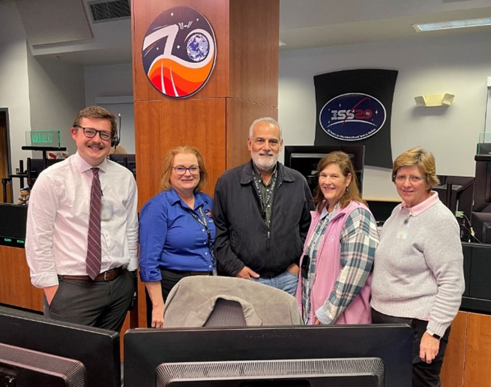 From left, Jacob Onken during his payload operations director (POD) certification ceremony with former PODs Carrie Olsen, Sam Digesu, Pat Patterson, and Tina Melton in the Payload Operations Center at Marshall.