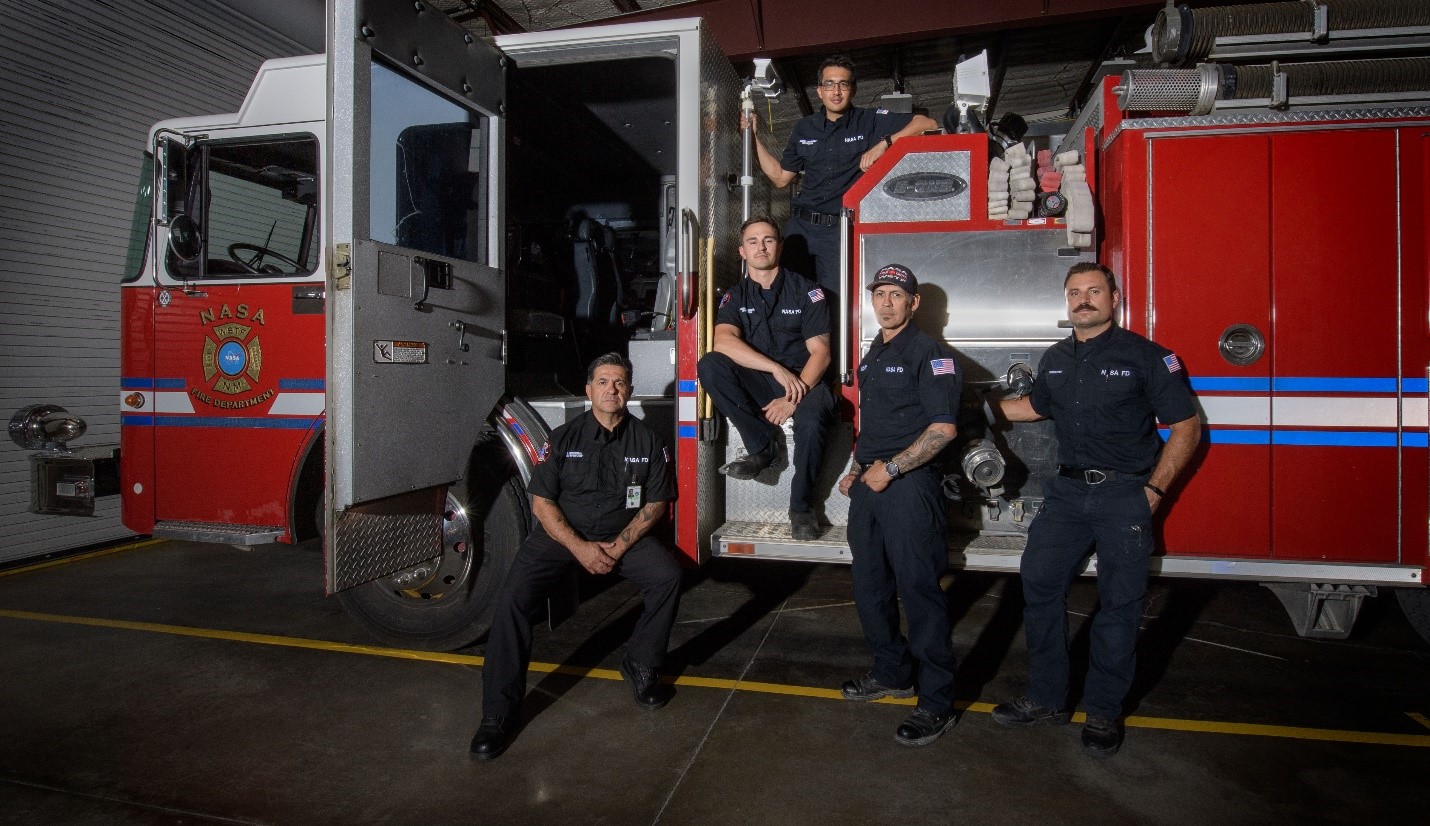 Members of the White Sands Test Facility Fire Department pose for a photo in front of a firetruck.