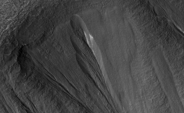 The white material seen within this Martian gully is believed to be dusty water ice