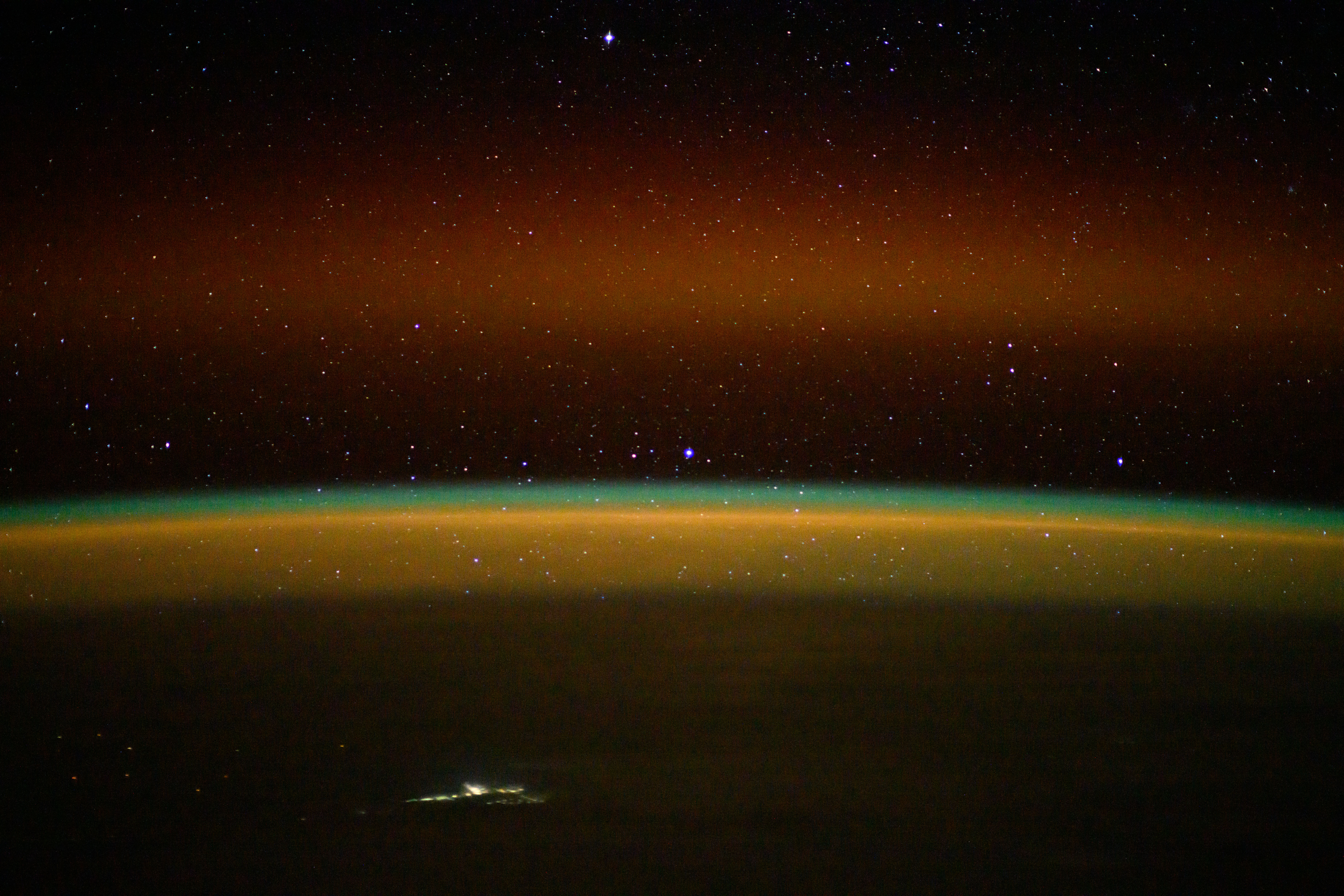 iss072e003466 (Sept. 29, 2024) -- As the International Space Station orbited 264 miles above the Northern Territory of Australia, NASA astronaut Jeanette Epps used long-exposure camera settings to capture an array of colors in Earth's horizon. A golden-green atmospheric glow crowns Earth's horizon, while stars shimmer above.