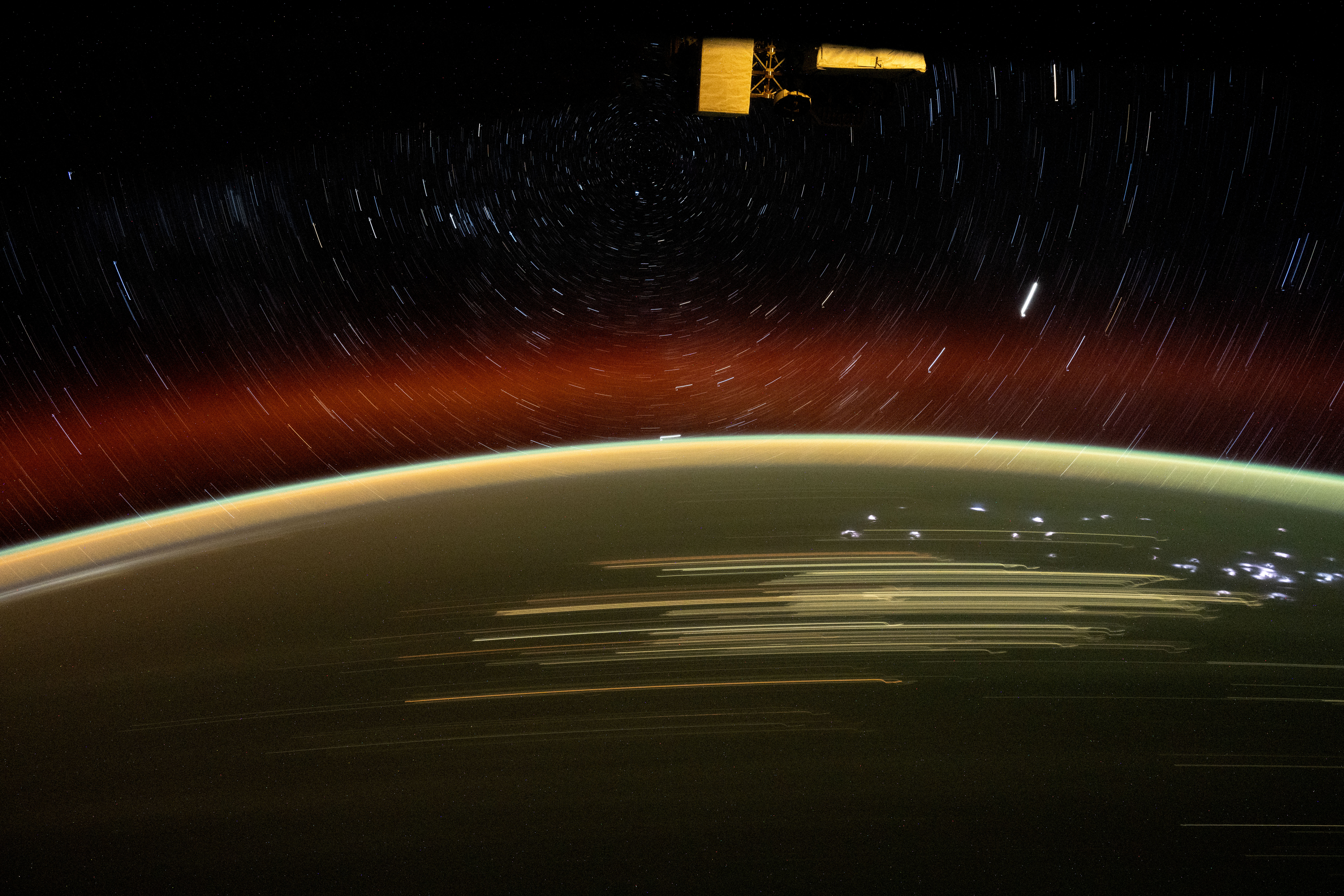 iss072e010734 (Oct. 1, 2024) -- As the International Space Station soared 266 miles over Western Australia, NASA astronaut Jeanette Epps captured this long-exposure shot of Earth at night and star trails glittering above the atmosphere.