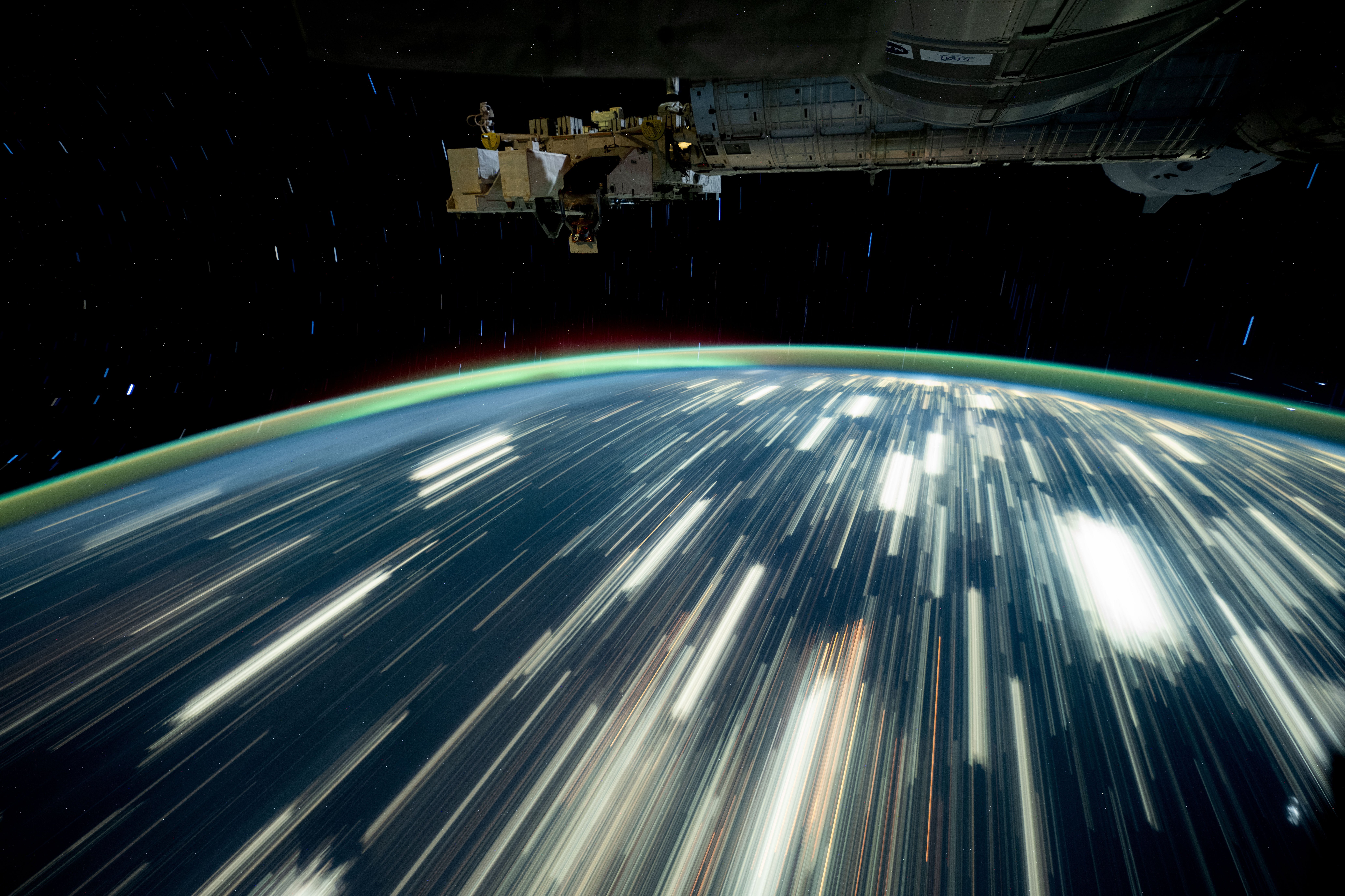 iss072e097437 (Oct. 24, 2024) -- As the International Space Station soared 257 miles above northern Mexico, NASA astronaut and Expedition 72 Flight Engineer Don Pettit captured this long-exposure photograph of city lights streaking across Earth while a green atmospheric glow crowned the horizon.