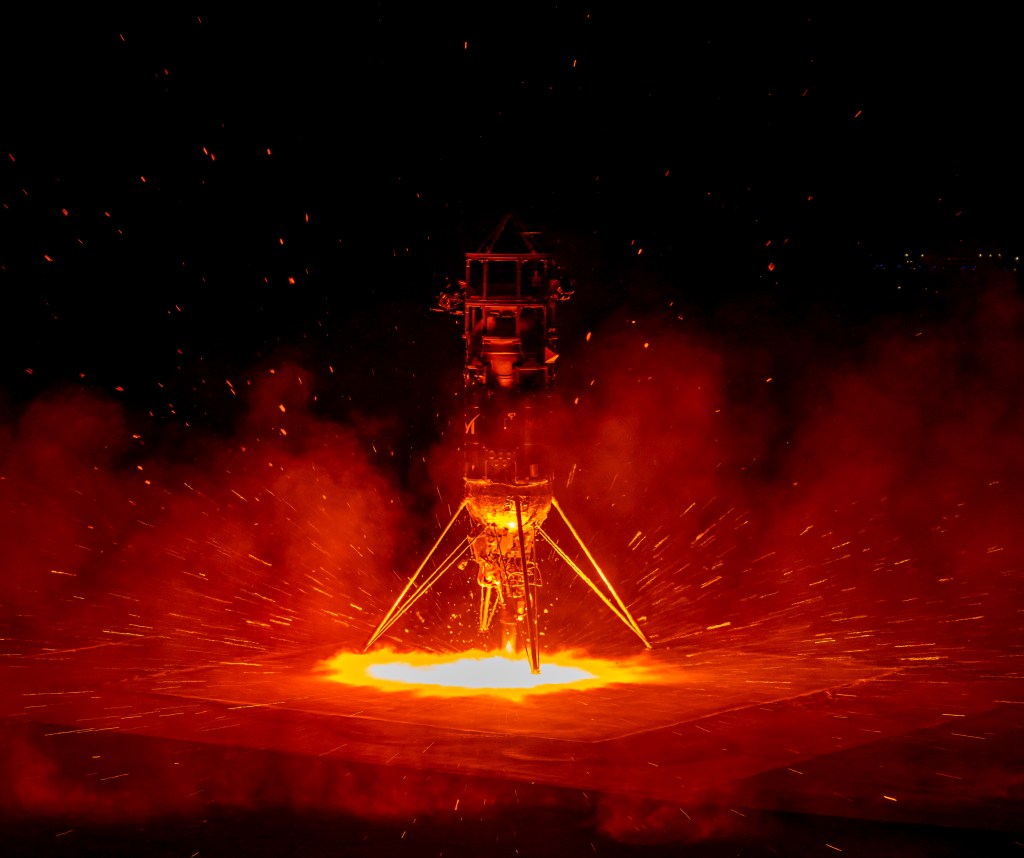Nighttime rocket launch with red glow.