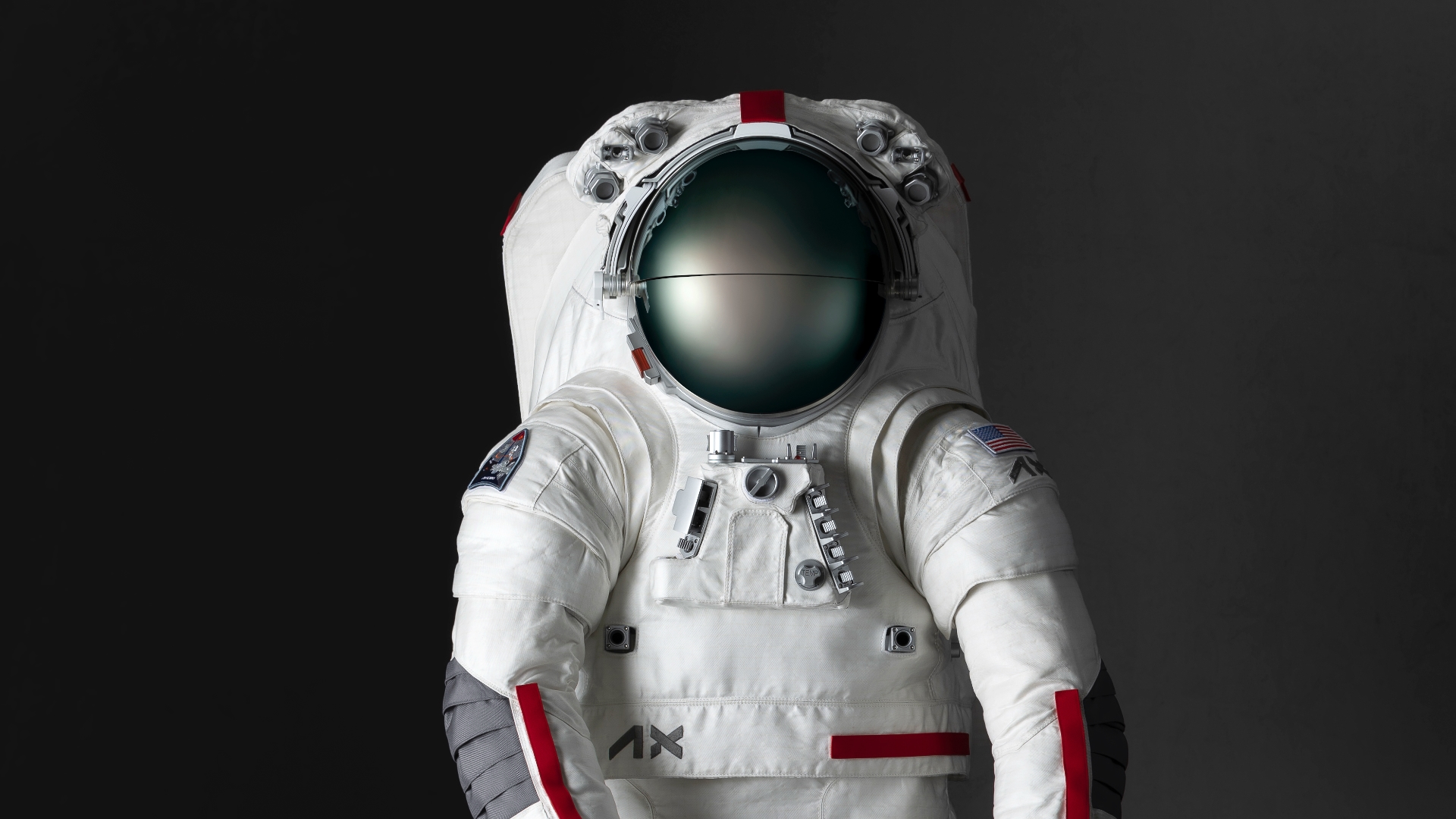 A closeup of the Axiom Space lunar spacesuit design from the waist up. The majority of the spacesuit is white with grey patches over the elbows and red trimming on the sleeves and torso.