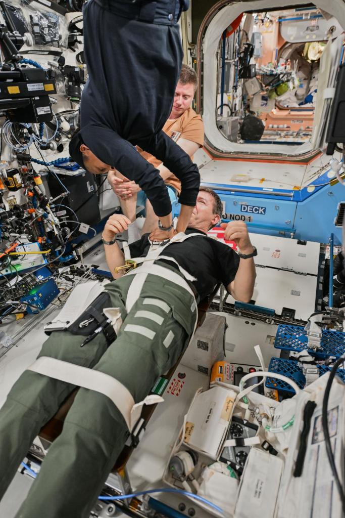 Flight Engineer Jeanette Epps practices CPR, or chest compressions, on Flight Engineer Mike Barratt