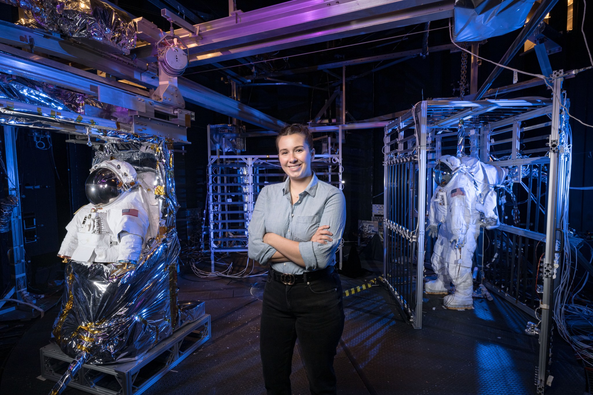 Miranda Peters stands in a spacesuit test chamber.