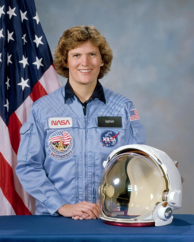 Kathryn Sullivan stands for a portrait wearing a light blue NASA jumpsuit.
