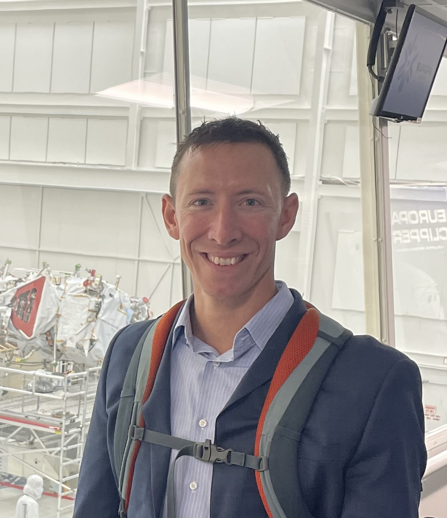 Portrait photo of Ryan Felton in a suit at an airport. Ryan works as a Postdoctoral Management Fellow with the Exobiology Branch at NASA Ames Research Center.