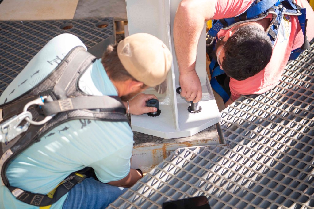 two team members work to secure an interstage simulator unit