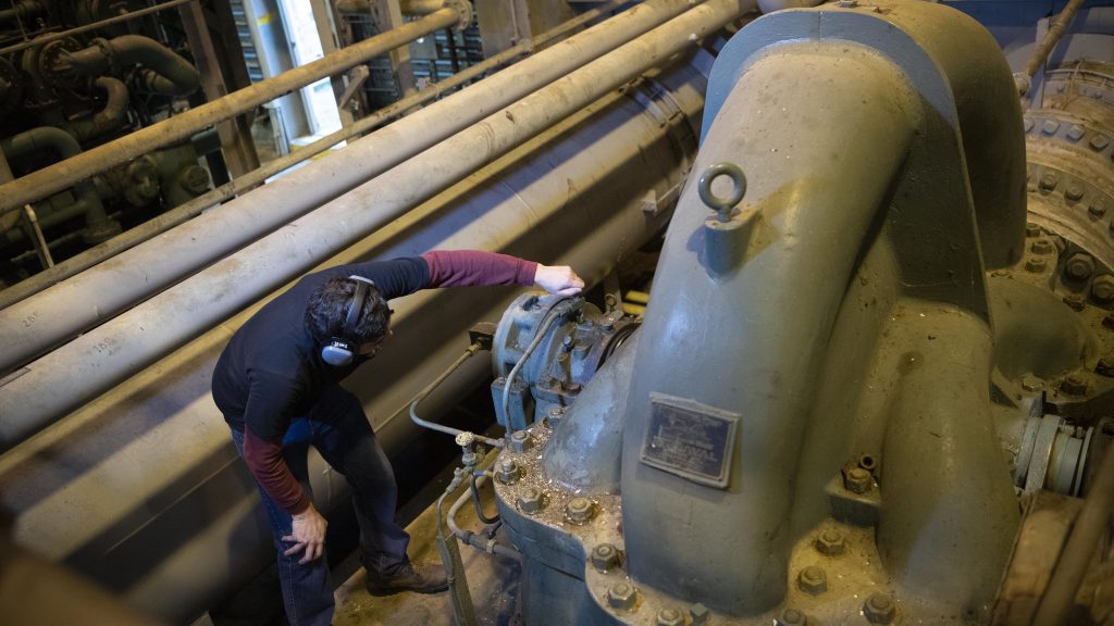 Crew member examines a component at the HPWF