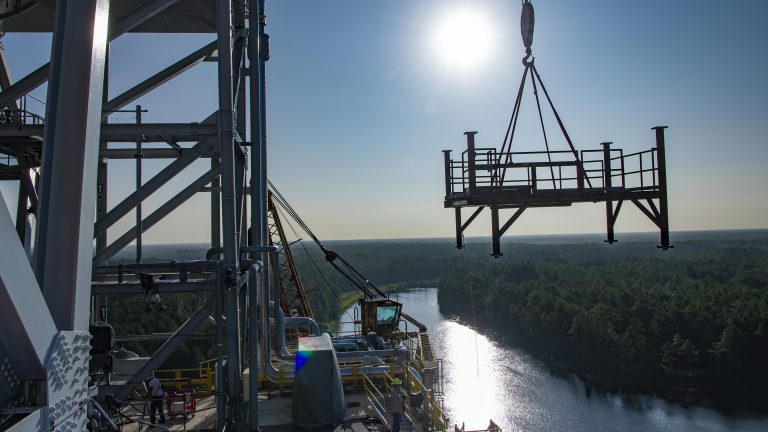 Crews perform a lift and fit operation of an umbilical support structure on the B-2 side of the Thad Cochran Test Stand