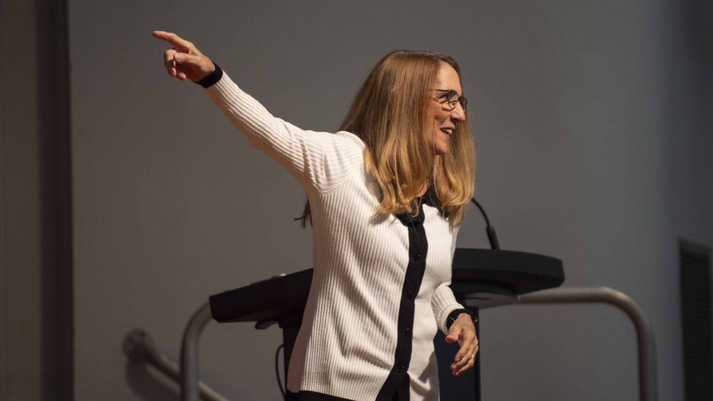 Former NASA astronaut Dr. Nancy Currie-Gregg pointing at projector screen during her speech