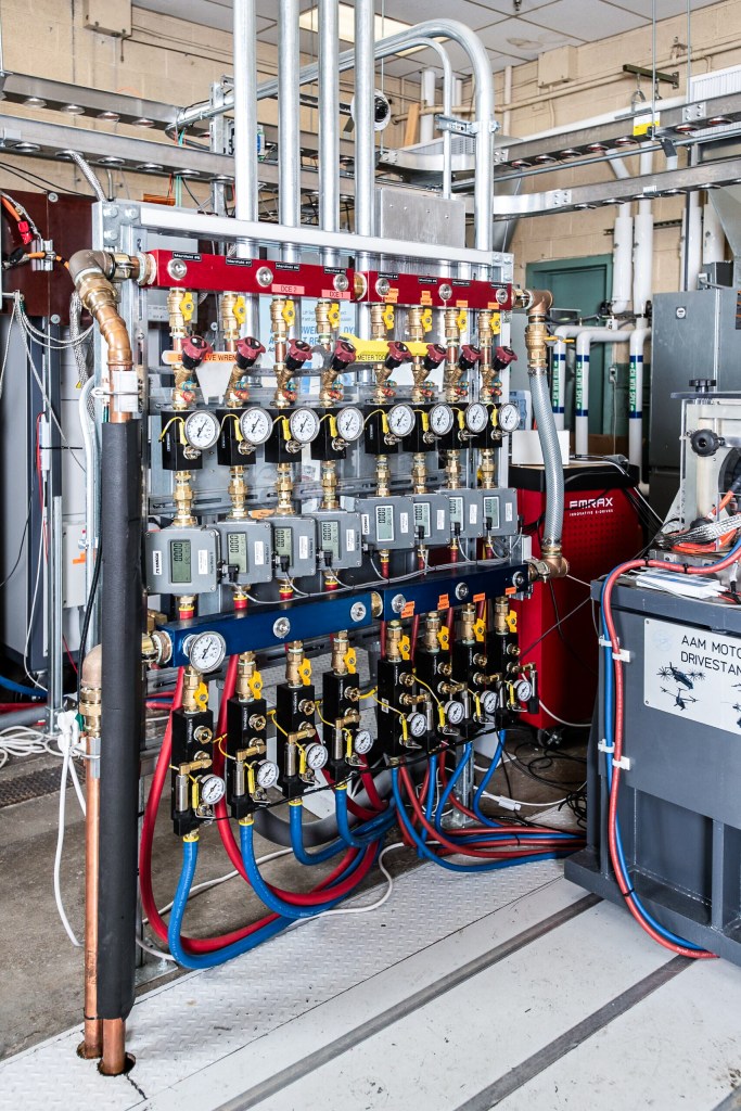Several gauges lined up along a stand with various wires and monitoring equipment attached.