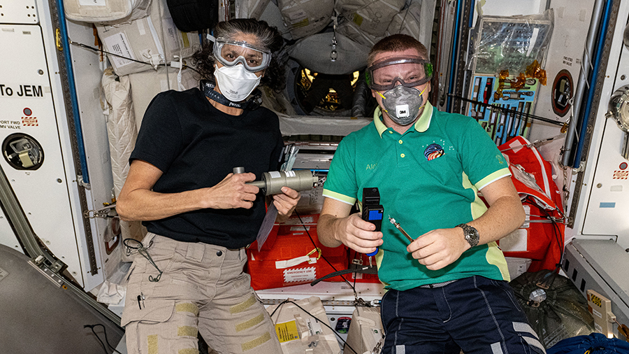 Expedition 72 crewmates Suni Williams of NASA and Aleksandr Gorbunov of Roscosmos wear personal protective equipment shortly after the hatches opened to the newly arrived SpaceX Dragon cargo spacecraft on Nov. 5, 2024. Photo credit: NASA