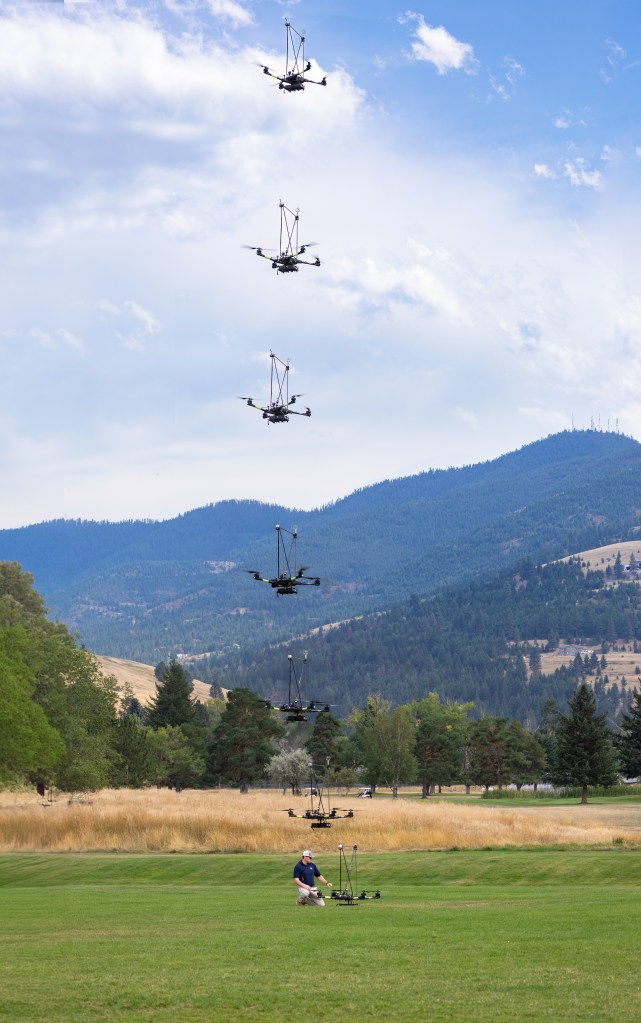 This composite image shows the NASA Alta X quadcopter taking off during one of eight flights it performed for the 2024 FireSense uncrewed aerial system (UAS) technology demonstration in Missoula, Montana. Mounted on top of the drone is a unique infrastructure designed at NASA Langley to carry a radiosonde and an anemometer – two sensors that measure wind speed and direction – into the sky. On the ground, UAS Pilot in Command Brayden Chamberlain performs final pre-flight checks.