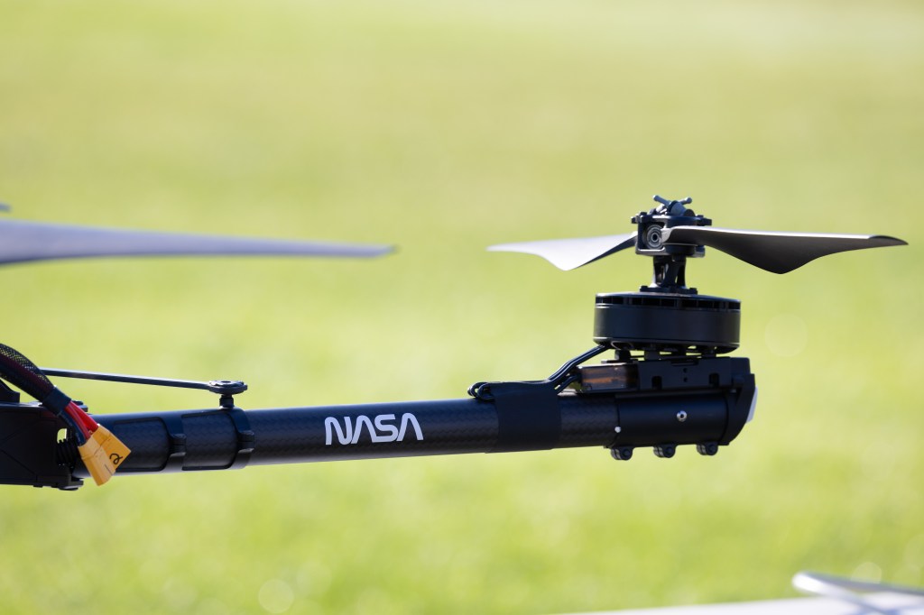 A rotor from the NASA Alta X quadcopter stretches over the grass at the University of Montana between launches. This uncrewed aerial system (UAS) carried two sensors, a radiosonde and an anemometer, to measure wind speed and direction during the 2024 FireSense UAS technology demonstration.