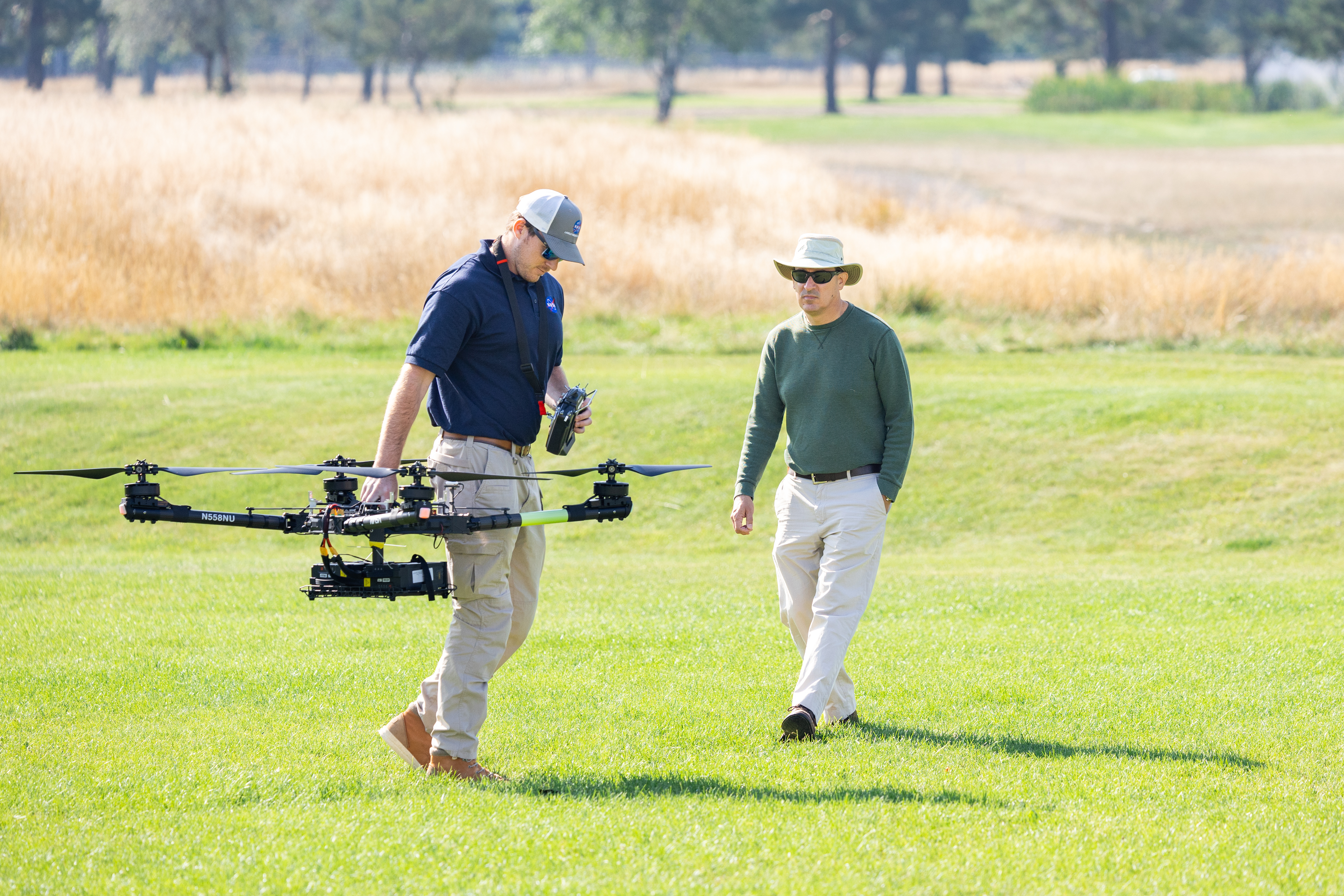 Brayden Chamberlain, UAS Pilot in Command, carries the NASA Alta X quadcopter during pre-flight calibrations ahead of the drone’s first flight for FireSense’s uncrewed aerial system (UAS) technology demonstration in Missoula, Montana.