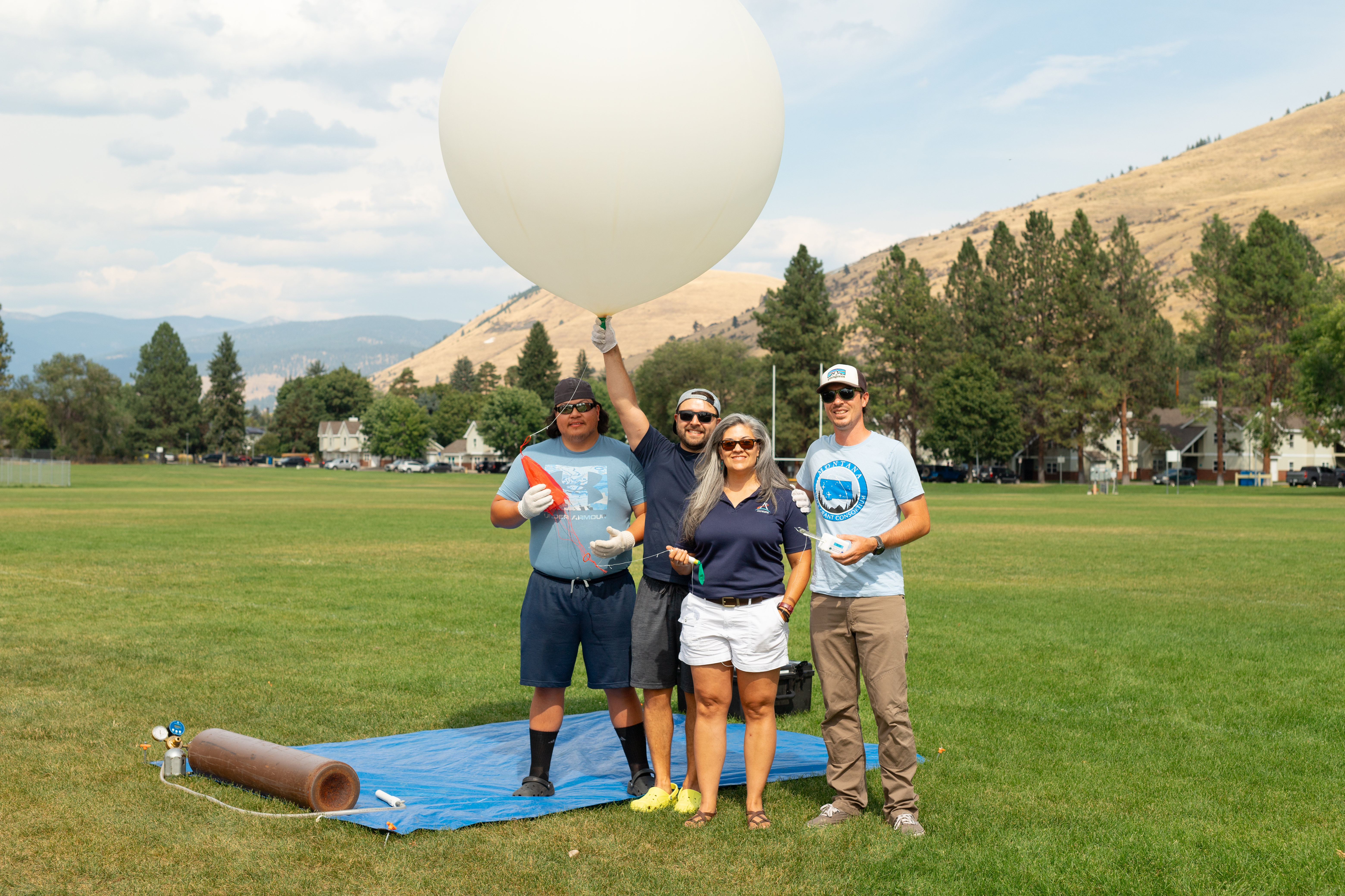 (From left) Travis Christopher, Danny Johnson, Meredith Heckler, and Steven Stratham pose with a weather balloon. This team from Salish Kootenai College is one of two teams that supported the FireSense UAS Technology Demonstration in Missoula, Montana.