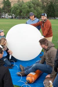 Weather balloon teams from University of Idaho and Salish Kootenai College prepare a weather balloon for launch on the second day of the FireSense campaign in Missoula, Montana.