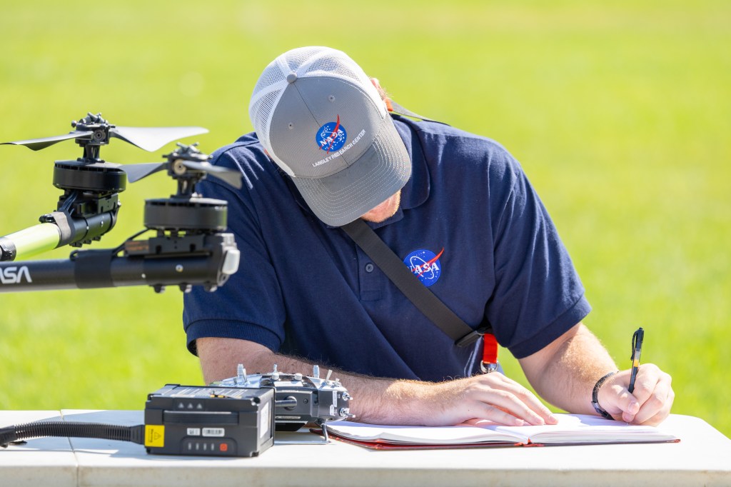 UAS Pilot in Command Brayden Chamberlain works to diagnose a calibration issue with the NASA Alta X quadcopter during the FireSense uncrewed aerial system (UAS) Technology Demonstration in Missoula, Montana.