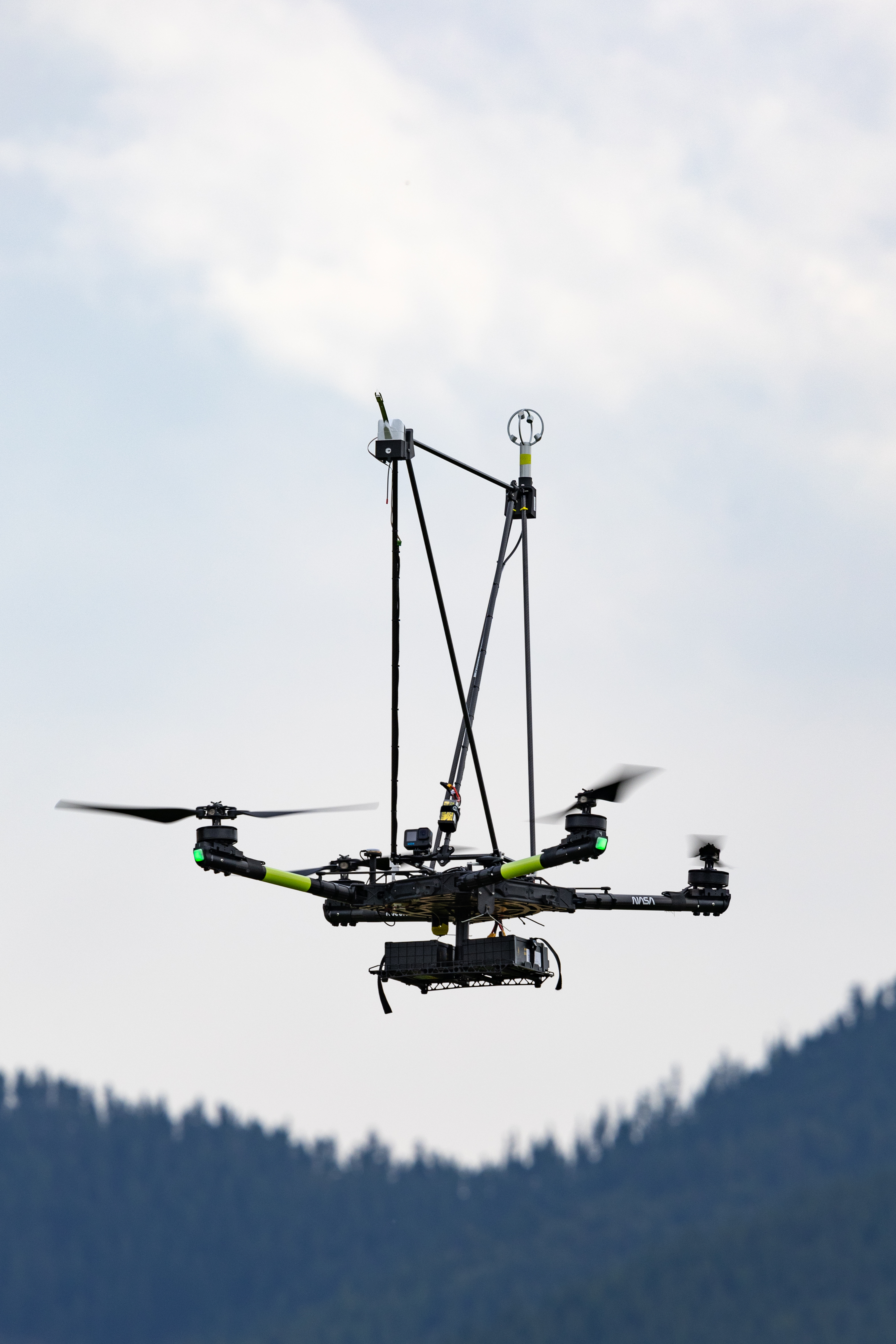 The NASA Alta X quadcopter descends over the mountains during one of eight launches for the FireSense uncrewed aerial system (UAS) Technology Demonstration in Missoula, Montana.