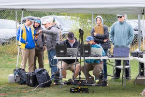 Team members from NASA and Salish Kootenai College stand in the control tent to watch the progress of the NASA Alta X quadcopter as it performs one of eight flights of the campaign.