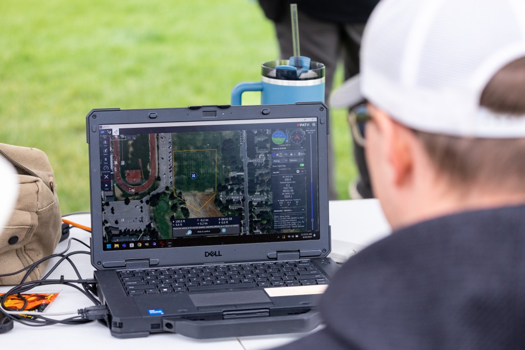 UAS Ground Station Operator Jacob Revesz plans flight paths for the NASA Alta X quadcopter and monitors progress from the ground control computer. The drone can also be piloted directly from the ground control computer if necessary.