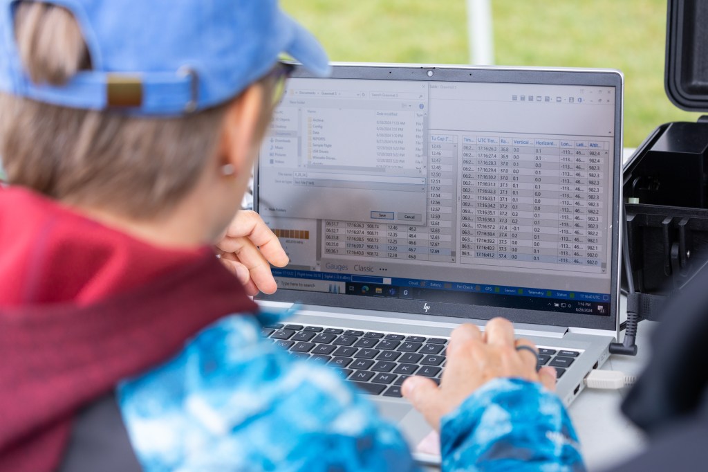 FireSense Project Manager Jennifer Fowler prepares data from recent launches to send to the National Weather Service, during the FireSense uncrewed aerial system (UAS) Technology Demonstration in Missoula, Montana.