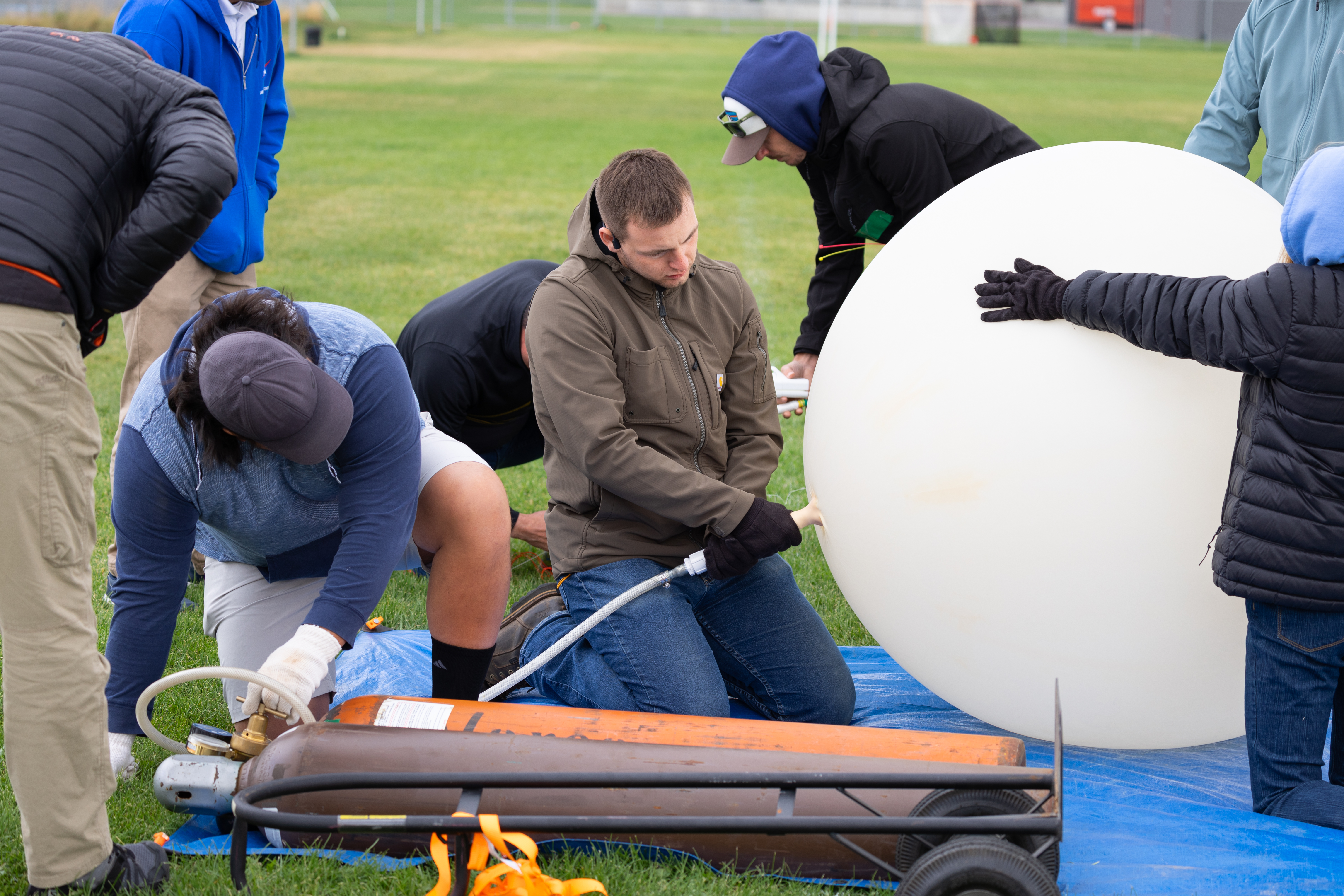 Danny Johnson (left) and Travis Christopher (right) inflate a weather balloon ahead of a launch, outfitted with a radiosonde sensor to gather data on wind speed and direction. This team from Salish Kootenai College is one of two teams that supported the FireSense UAS Technology Demonstration in Missoula, Montana.