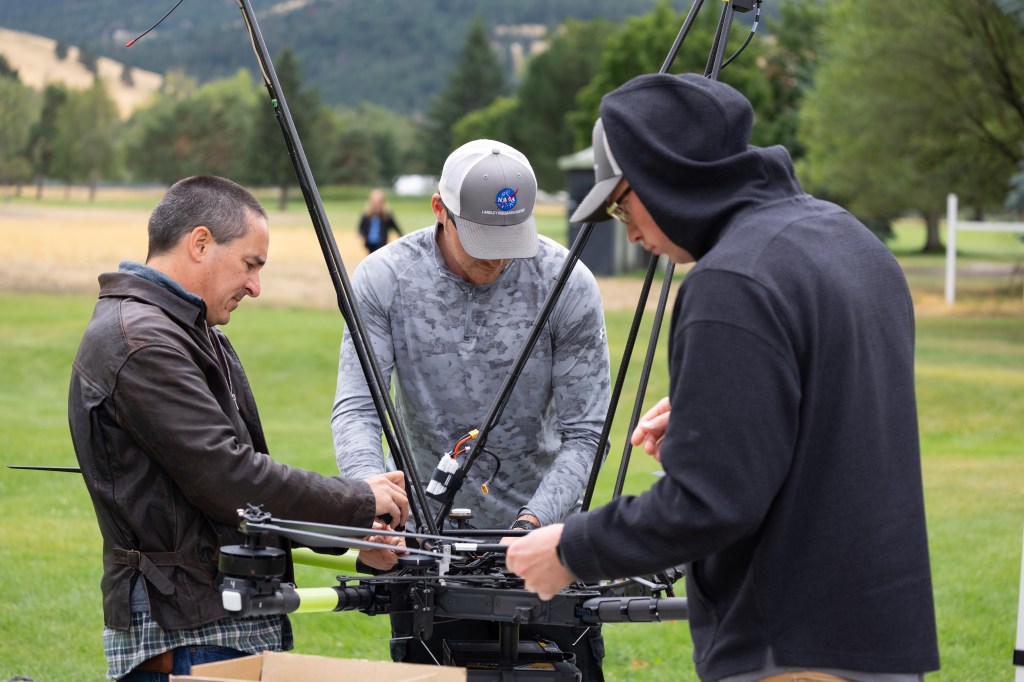 NASA Langley drone team members (from left) Todd Ferrante, Brayden Chamberlain, and Jacob Revesz check the NASA Alta X quadcopter between launches during the FireSense uncrewed aerial system (UAS) Technology Demonstration in Missoula, Montana.