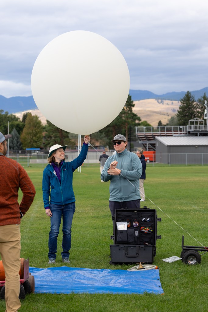 FireSense Project Scientist Jacquelyn Shuman prepares to release a weather balloon into the sky on the last day of the FireSense uncrewed aerial system (UAS) Technology Demonstration in Missoula, Montana. The weather balloon is outfitted with a radiosonde sensor, which provides data on wind speed and direction.