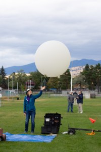FireSense Project Scientist Jacquelyn Shuman releases a weather balloon into the sky on the last day of the FireSense uncrewed aerial system (UAS) Technology Demonstration in Missoula, Montana. The weather balloon is outfitted with a radiosonde sensor, which provides data on wind speed and direction.