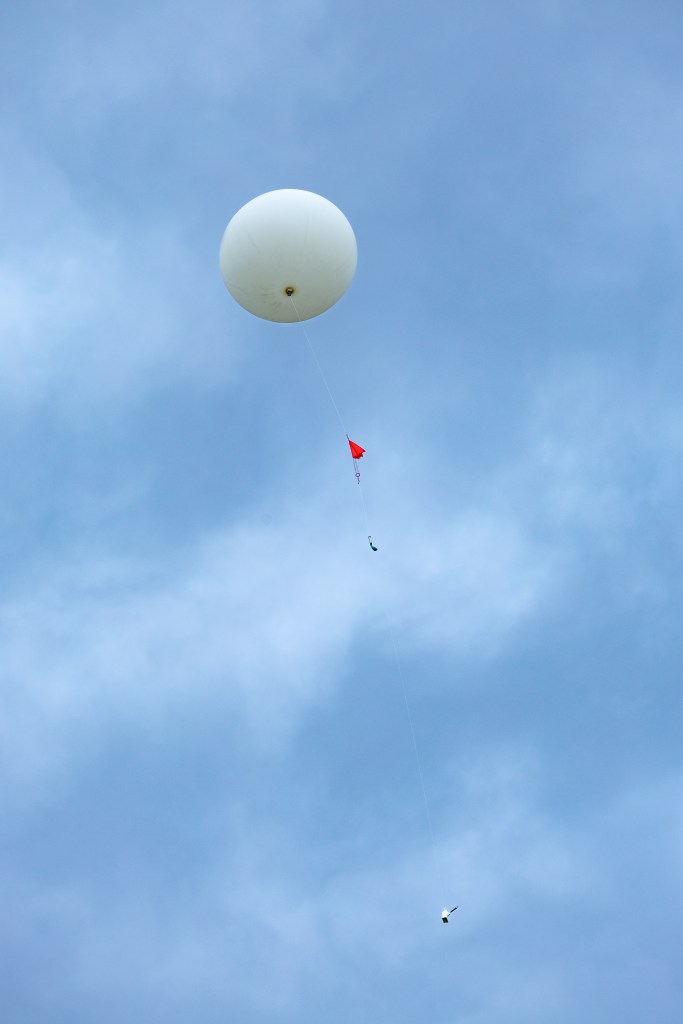 : A weather balloon carrying a radiosonde sensor flies into the sky before vanishing from sight. The radiosondes provide data on wind speed and direction, and are currently used across the United States for weather forecasting.