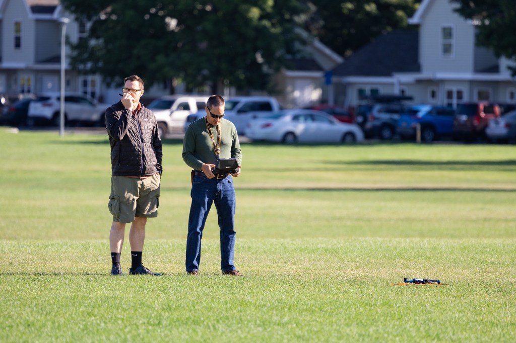 Tim Wallace radios in to request clearance for takeoff while Todd Ferrante prepares the Skydio-2 drone for launch during the last day of the FireSense uncrewed aerial system (UAS) technology demonstration in Missoula, Montana.