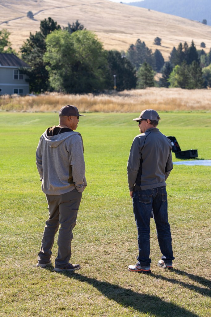 US Forest Service members Chris Bolz (left) and Evan Day (right) watch the final launch of the NASA Alta X quadcopter during the FireSense uncrewed aerial system (UAS) technology demonstration in Missoula, Montana. The US Forest Service is a potential user of this technology, as increased accuracy and repeatability of wind forecasting could greatly improve fire behavior predictions.