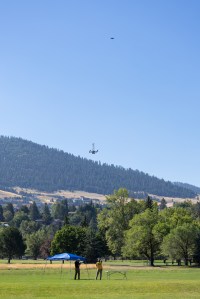 UAS Pilot in Command Brayden Chamberlain (left) and Range Safety Officer Dustin Schmitt (right) watch the NASA Alta X quadcopter as it descends from its final flight of the FireSense uncrewed aerial system (UAS) technology demonstration in Missoula, Montana.