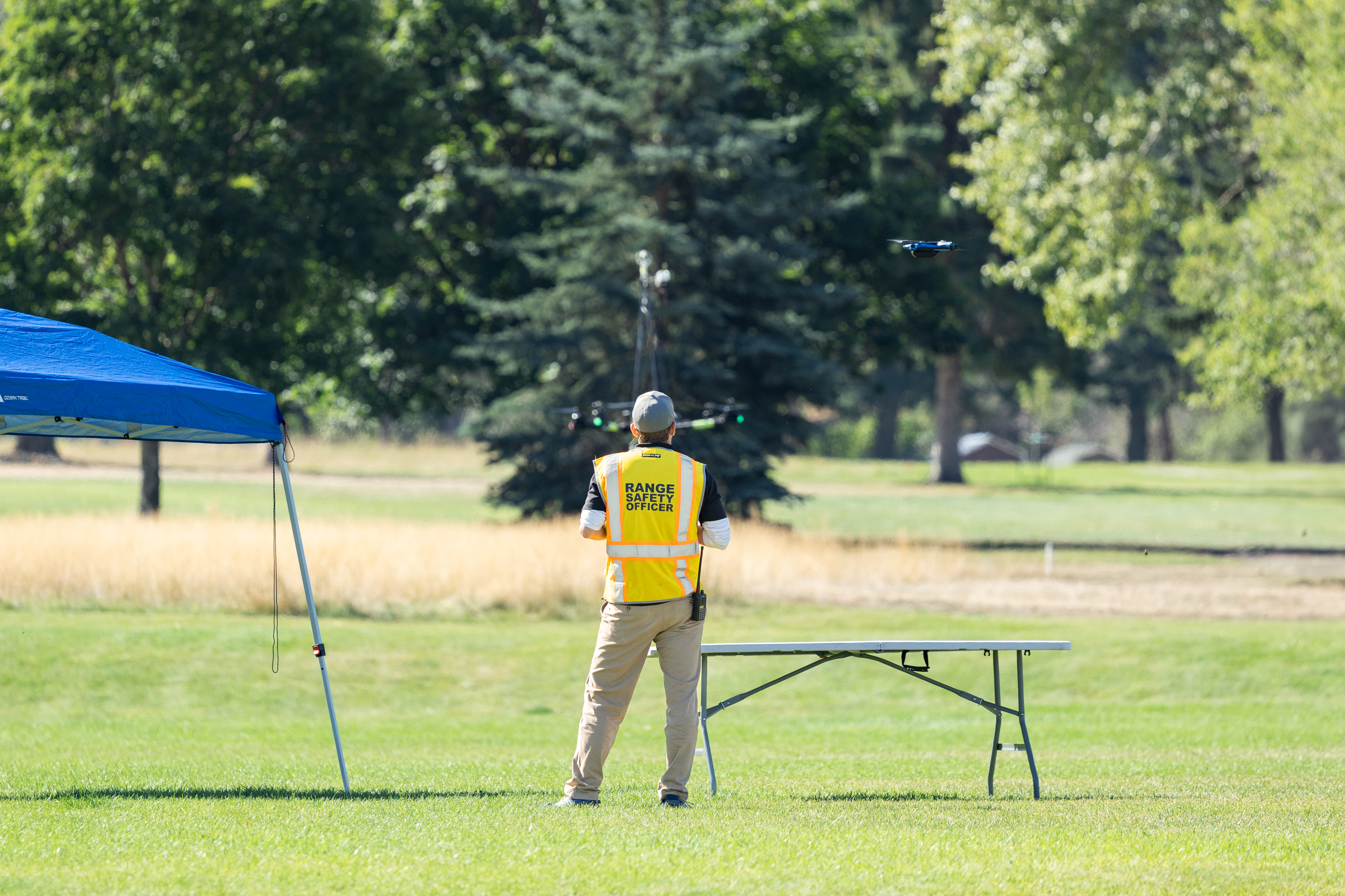 Range Safety Officer Dustin Schmitt watches the NASA Alta X quadcopter and the Skydio-2 drone as they descend from the final flight of the FireSense uncrewed aerial system (UAS) technology demonstration in Missoula, Montana.