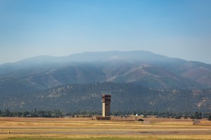 Smoke from the nearby Miller Peak Fire drifts by the air control tower at Missoula Montana Airport on August 29, 2024. Miller Peak was one of several fires burning in and around Missoula that month, creating a smoke-impacted environment which, combined with the mountainous terrain, makes traditional forecasting methods difficult: a problem the FireSense team is working to solve.