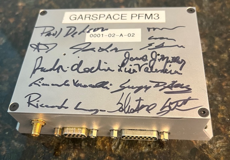 Silver box with several signatures covering the surface and cable connections at one end. GARSPACE PRM3 and 0001-02-A-02 written at the top.