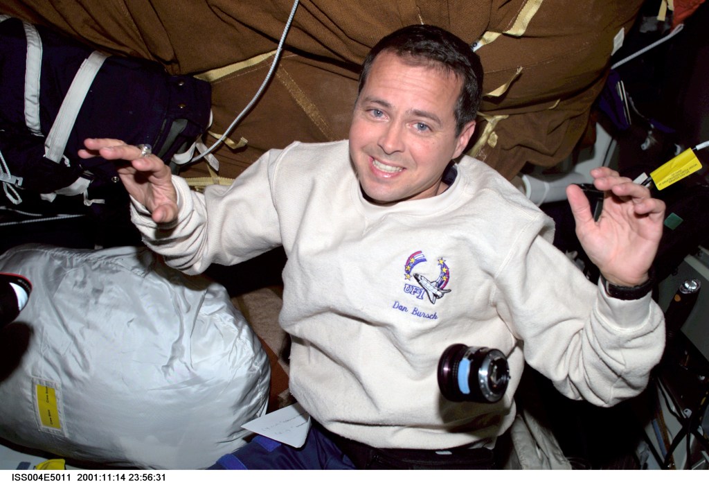ISS004-E-5011 (December 2001) --- Astronaut Daniel W. Bursch, Expedition Four flight engineer, is photographed with stowage bags on the mid deck of the Space Shuttle Endeavour. The image was taken with digital still camera.