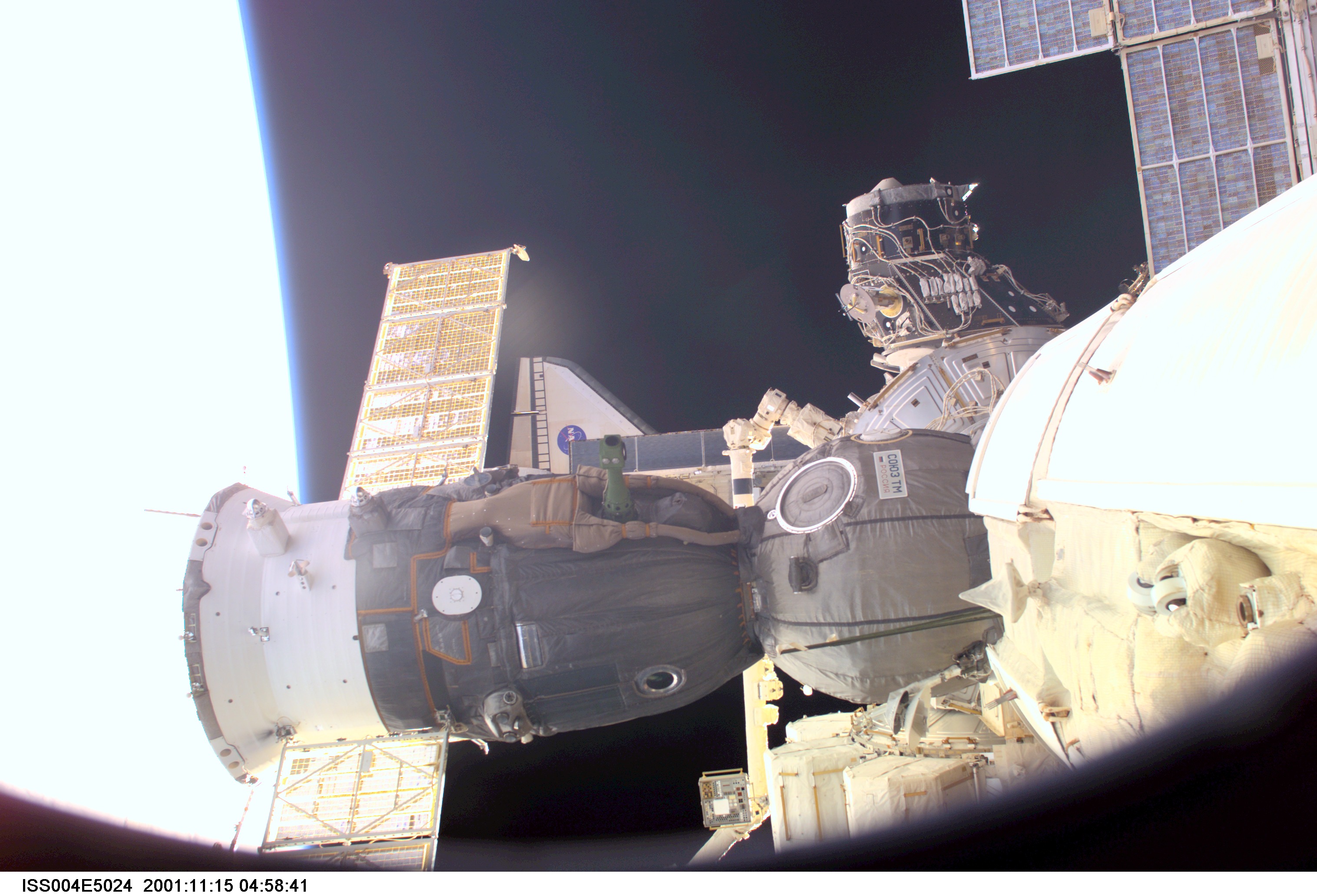 ISS004-E-5024 (15 December 2001) --- A Soyuz vehicle, docked to the International Space Station (ISS), is photographed by a crewmember on the station. A portion of the Space Shuttle Endeavour is visible in the background. The image was taken with a digital still camera.