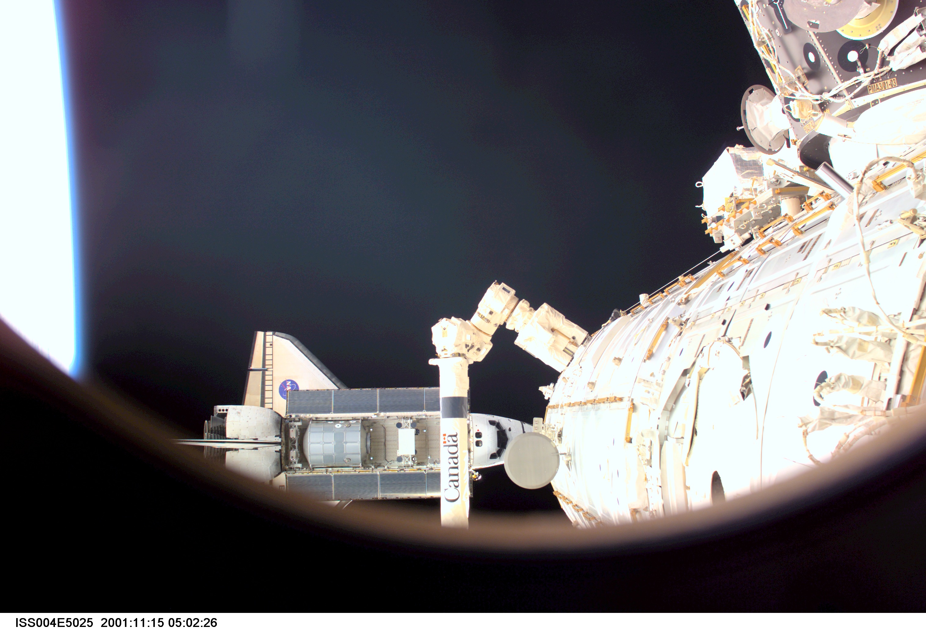 ISS004-E-5025 (15 December 2001) --- As seen through a window on the International Space Station (ISS), the Space Shuttle Endeavour is photographed...