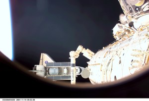 ISS004-E-5025 (15 December 2001) --- As seen through a window on the International Space Station (ISS), the Space Shuttle Endeavour is photographed as it undocks from the station. A portion of the Canadarm2 is visible in the foreground. The image was taken with at digital still camera.