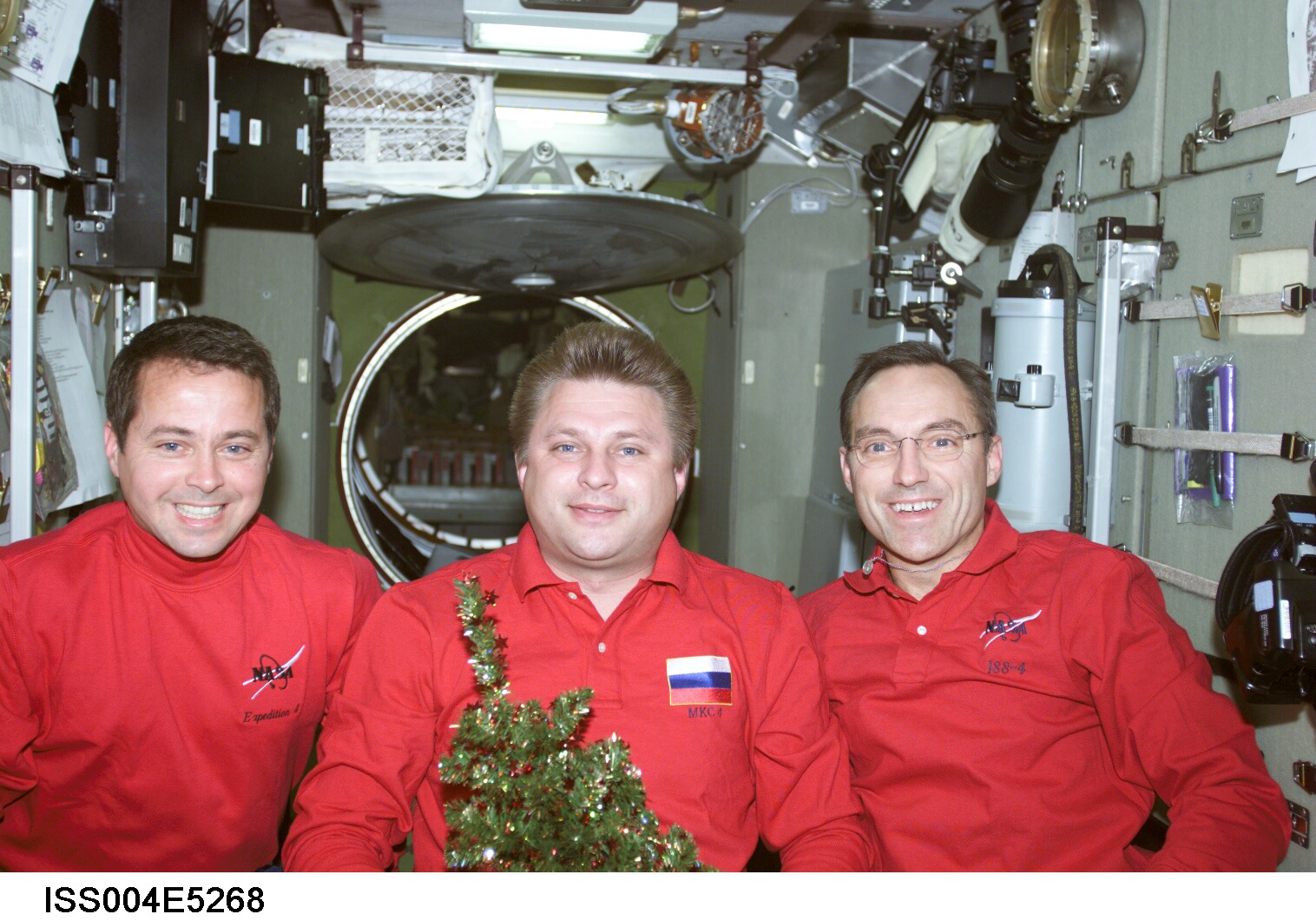 ISS004-E-5268 (December 2001) --- Cosmonaut Yuri I. Onufrienko, Expedition Four mission commander, flanked by astronauts Daniel W. Bursch (left) and Carl E. Walz, both flight engineers, pose for an informal holiday crew photo in the Zvezda Service Module on the International Space Station (ISS). Onufrienko represents Rosaviakosmos. The image was taken with a digital still camera.