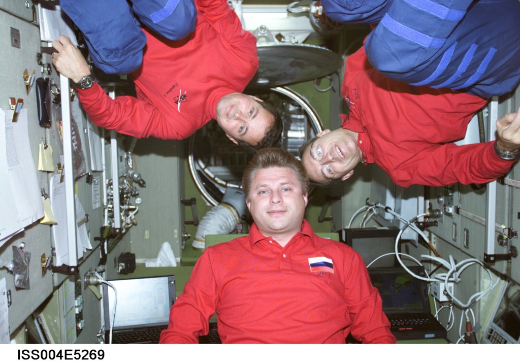 ISS004-E-5269 (December 2001) --- Cosmonaut Yuri I. Onufrienko, Expedition Four mission commander, flanked by astronauts Daniel W. Bursch (left) and Carl E. Walz, both flight engineers, pose for an informal crew photo in the Zvezda Service Module on the International Space Station (ISS). Onufrienko represents Rosaviakosmos. The image was taken with a digital still camera.