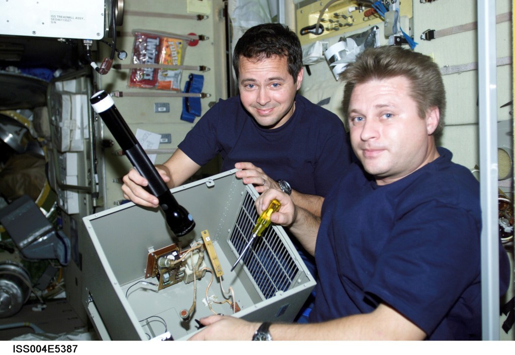 ISS004-E-5387 (January 2002) --- Cosmonaut Yuri I. Onufrienko (right), Expedition Four mission commander, and astronaut Daniel W. Bursch, flight engineer, perform maintenance on equipment in the Zvezda Service Module on the International Space Station (ISS). Onufrienko represents Rosaviakosmos. The image was taken with a digital still camera.