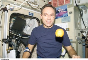 ISS004-E-6336 (January 2002) --- Astronaut Carl E. Walz, Expedition Four flight engineer, is photographed in the Zvezda Service Module on the International Space Station (ISS). An orange floats freely in front of Walz. The image was taken with a digital still camera.