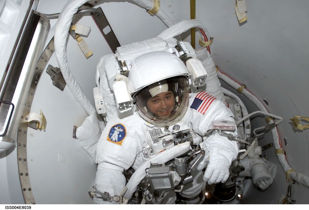 ISS004-E-8039 (20 February 2002) --- Astronauts Daniel W. Bursch and Carl E. Walz (obscured) go through preparations in the crew lock of Quest prior to the February 20 space walk. The photograph was taken with a digital still camera by cosmonaut Yury I. Onufrienko, Expedition Four commander. Onufrienko remained onboard the International Space Station (ISS) while the two flight engineers, attired in NASA extravehicular mobility units (EMU), worked on the orbital outpost, logging a total of 5-hours, 47-minutes outside the station. The two tested equipment and procedures for the Airlock Quest and performed other tasks to prepare for Space Shuttle Atlantis’ STS-110 mission in April. The space walk began at 5:38 a.m. (CST) and ended at 11:25 a.m.