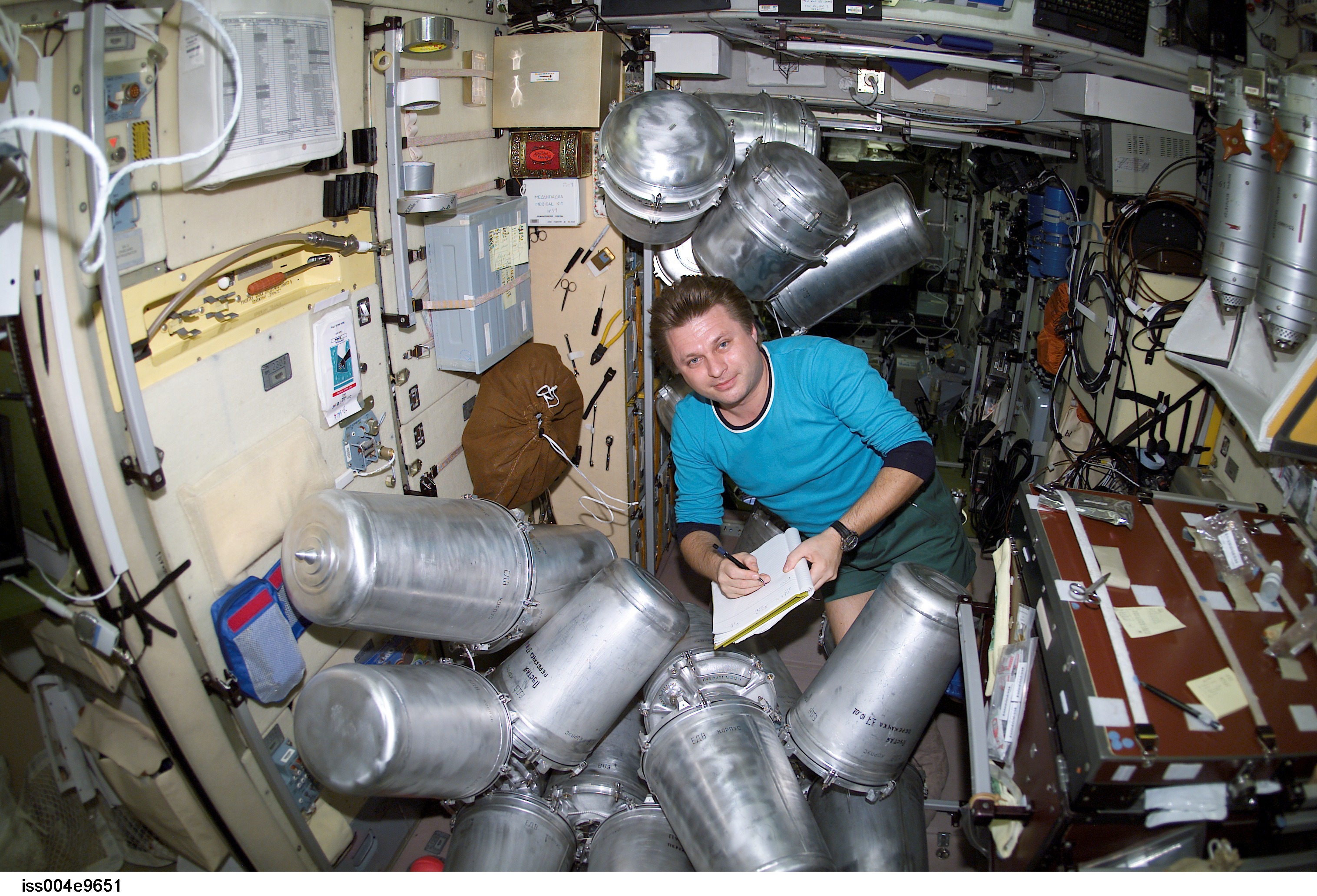 ISS004-E-9651 (11 March 2002) --- Cosmonaut Yury I. Onufrienko, Expedition Four mission commander, catalogs canisters of water in the Zvezda Service Module on the International Space Station (ISS).