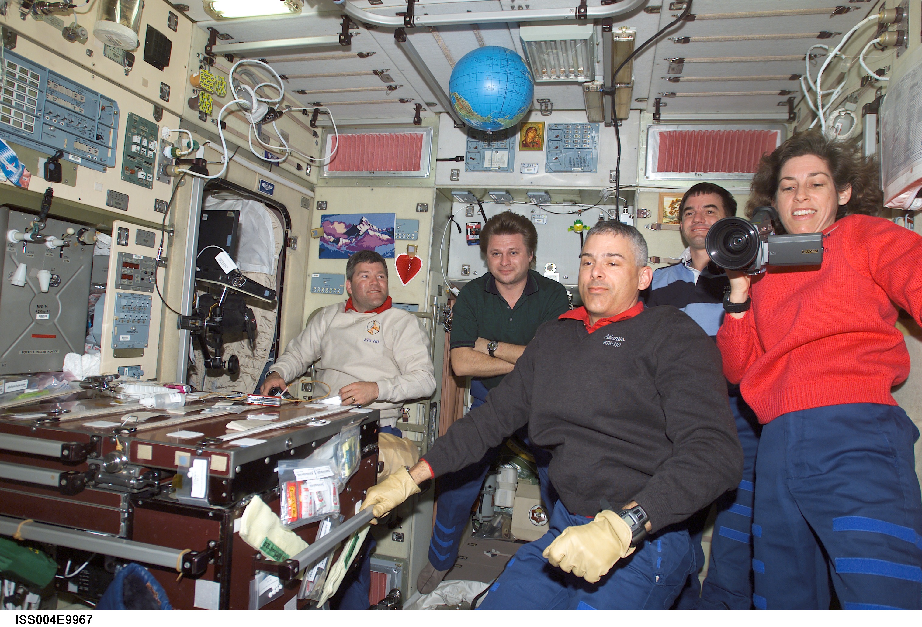 ISS004-E-9967 (10 April 2002) --- Astronauts Lee M. E. Morin (left foreground) and Ellen Ochoa, both STS-110 mission specialists; along with astronaut Stephen N. Frick (left background), STS-110 pilot, cosmonaut Yury I. Onufrienko, Expedition Four mission commander, and astronaut Rex J. Walheim, STS-110 mission specialist, are photographed in the Zvezda Service Module on the International Space Station (ISS).